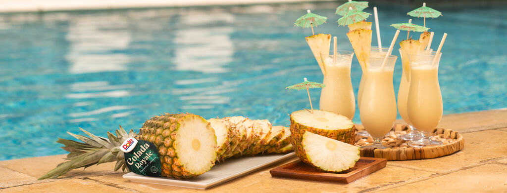 Sliced Colada Royale Pineapples near glasses of cocktails