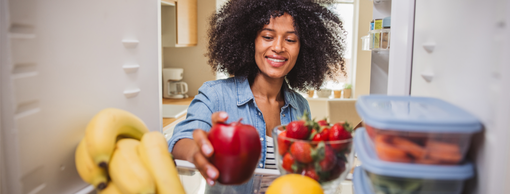 Women opening a fridge containing Dole fruits