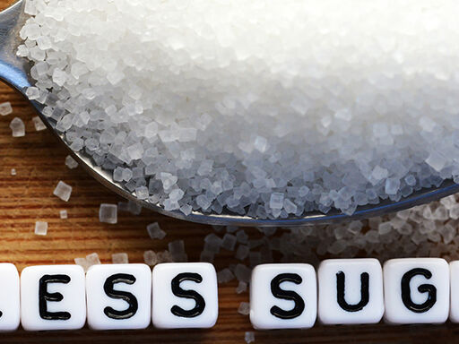 Image of a spoonful of sugar with the text less sugar below it