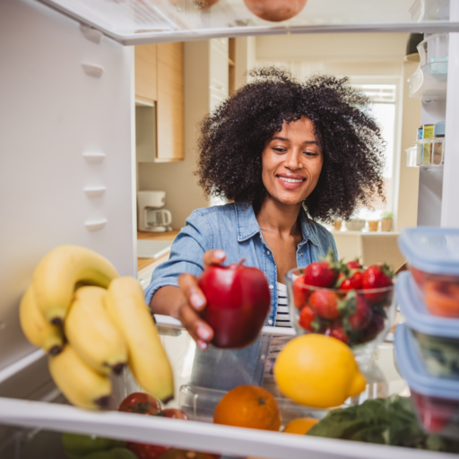 Lady taking dole fruits from her fridge